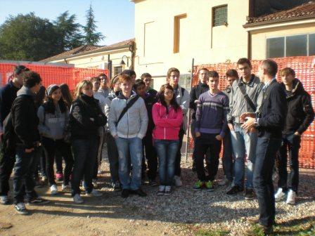 un gruppo di studenti ascolta le spiegazioni di un responsabile del cantiere.